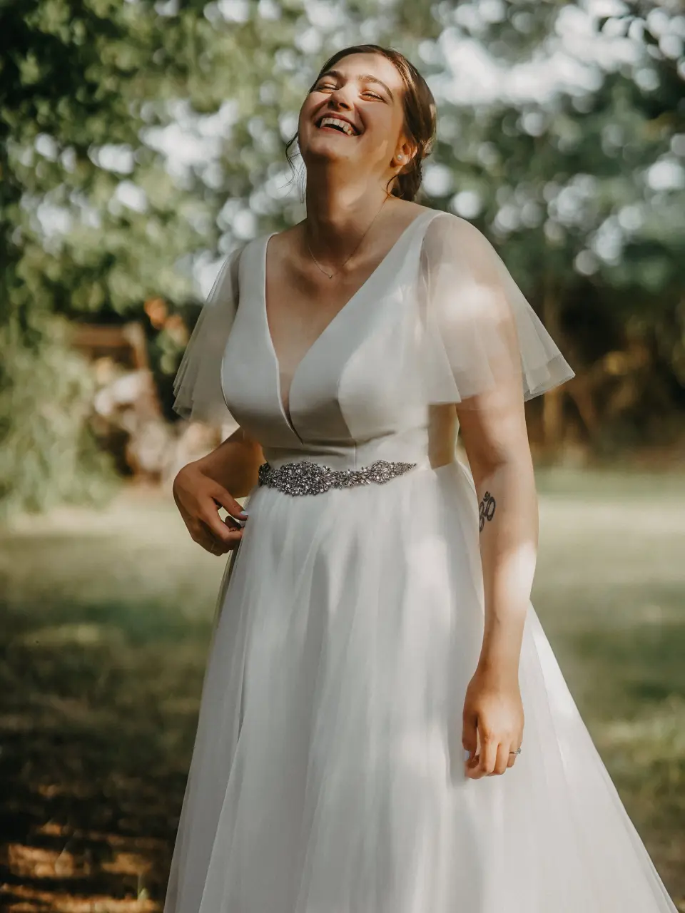 Braut mit weissem Kleid lachend